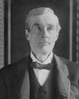 Black and white portrait of the 1st Duke of Westminster, an older man with short grey hair, in a dark coat and bow tie