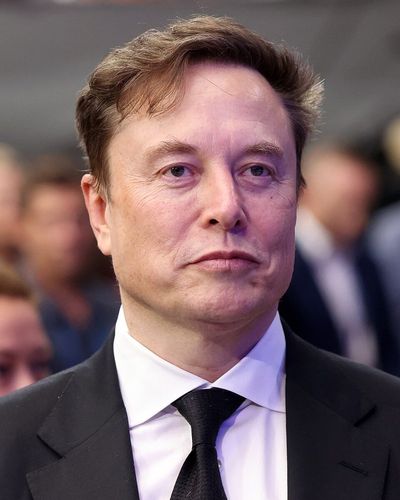 Elon Musk in a dark suit and tie