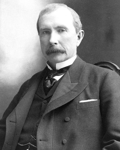 John D. Rockefeller in 1895, with a moustache, in a dark suit and tie